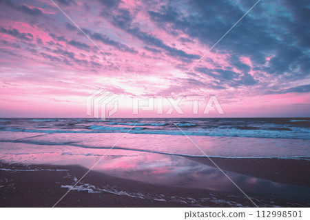 Seascape in the evening. Sunset over the sea with the beautiful cloudy blazing sky 112998501