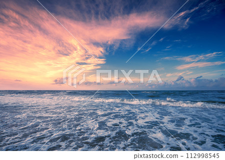 Seascape in the evening. Sunset over the sea with the beautiful dramatic blazing sky 112998545