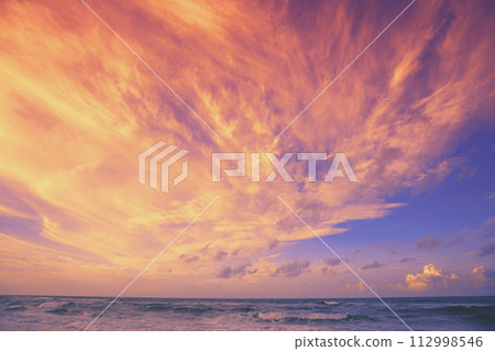Seascape in the evening. Sunset over the sea with the beautiful dramatic blazing sky Seascape in the evening. Sunset over the sea with the beautiful dramatic blazing sky 112998546