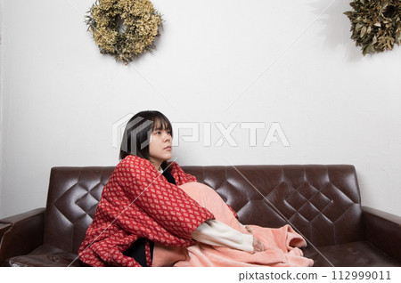 A woman doing physical education sitting on the sofa 112999011
