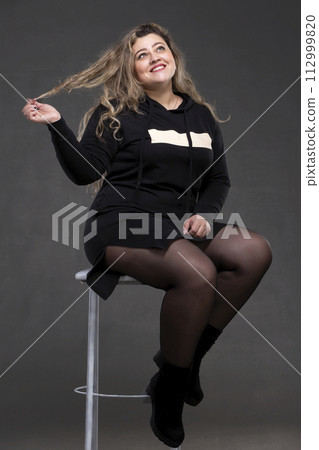 A beautiful fat woman with long curly hair sits... - Stock Photo  [112999820] - PIXTA