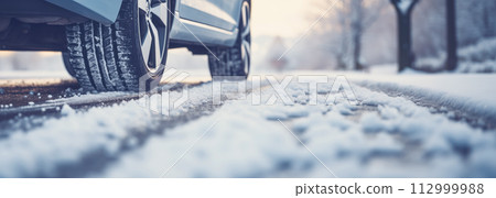 Closeup view of the car's wheel on the snowy road in natural park 112999988