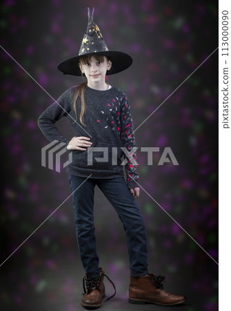 Little girl in a witch's hat on a background with colored spots. A child at the hallowen holiday. 113000090