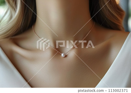 A woman is showcasing a pearl necklace on her neck 113002371