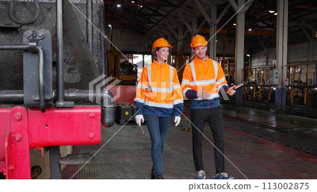 Team young caucasian engineer man and woman walking check and maintenance train in station, team engineer inspect system transport, technician checking infrastructure, transportation and industry. 113002875