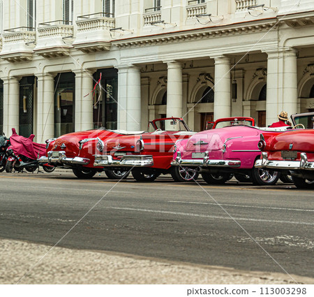Bright retro cars on Havana street near the hotel. 113003298