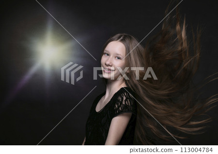 Portrait of a beautiful teenage girl with fluttering strands of hair. 113004784