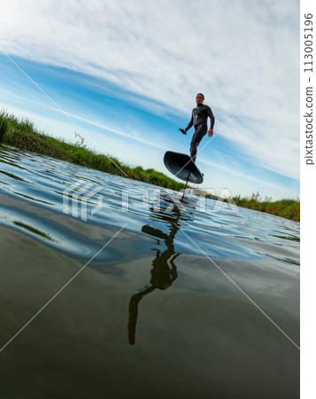 Hydrofoil rider gliding over the water Hydrofoil rider gliding over the water 113005196