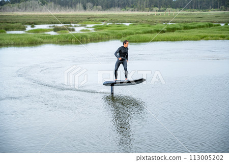 Hydrofoil rider gliding over the water 113005202