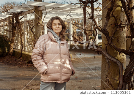 Young beautiful pretty tourist girl in warm hat and coat with backpack walking at cold autumn in Europe city enjoying her travel in Bietigheim-Bissingen, Deutschland. Outdoor portrait of young tourist Young beautiful pretty tourist girl in warm hat and coat with backpack walking at cold autumn in Europe city enjoying her travel in Bietigheim-Bissingen, Deutschland. Outdoor portrait of young tourist 113005361