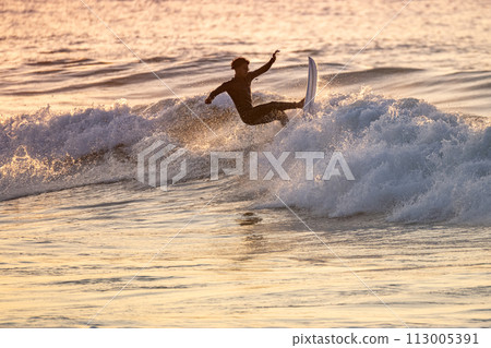 Young surfer enjoying waves 113005391