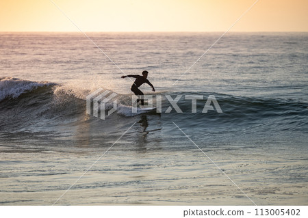 Young surfer enjoying waves 113005402