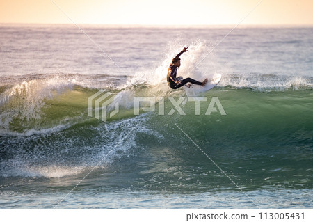 Brave teenager making tricks on the rough sea 113005431