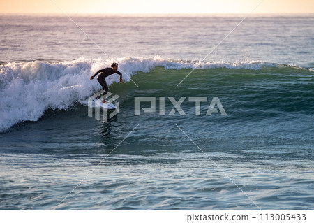 Sporty boy riding his surf board 113005433