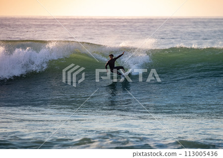 Sporty boy riding his surf board 113005436
