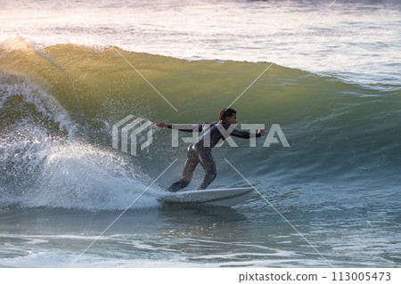 Young surfer enjoying waves Young surfer enjoying waves 113005473
