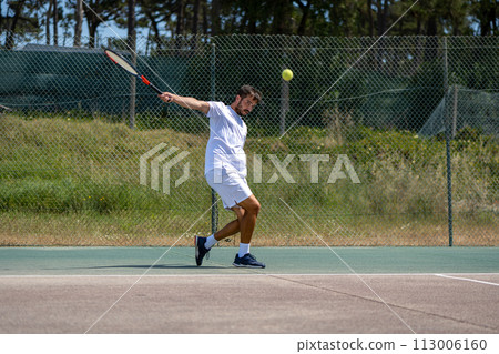 Tennis player hitting backhand at ball 113006160
