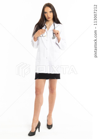 The young doctor holds a stethoscope with her hands and looks straight ahead. The young doctor holds a stethoscope with her hands and looks straight ahead. 113007212