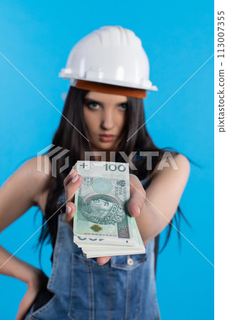 A young construction manager distributes banknotes to everyone who starts working together. 113007355