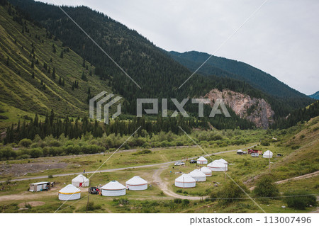 Kyrgyz Yurt Camp in Mountains, Nomadic Village by River Under Cloudy Sky 113007496