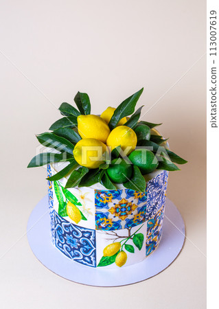 Cake decorated with lemons, leaves, ceramic tiles pattern on beige background Cake decorated with lemons, leaves, ceramic tiles pattern on beige background 113007619