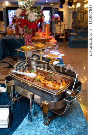 Close-up of a marmite buffet with a delicious beef dish inside 113007635