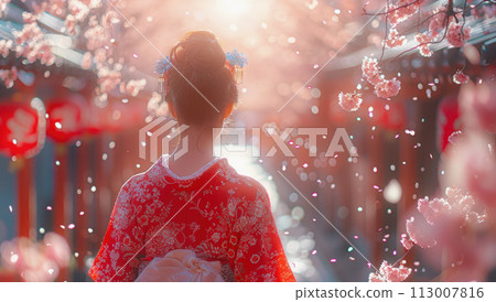 A woman in a red kimono stands under cherry blossom trees 113007816