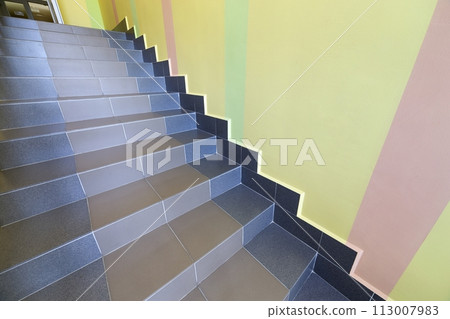 Wide staicase covered with ceramic tiles indoors in a house interior. Wide staicase covered with ceramic tiles indoors in a house interior. 113007983