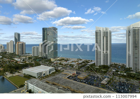 View from above of luxurious highrise hotels and condos on Atlantic ocean shore in Sunny Isles Beach city. American tourism infrastructure in southern Florida 113007994