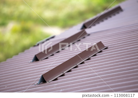 Metal brown shingle tiling house roof surface, rain gutter pipe and snow guards protective fence. Metal brown shingle tiling house roof surface, rain gutter pipe and snow guards protective fence. 113008117