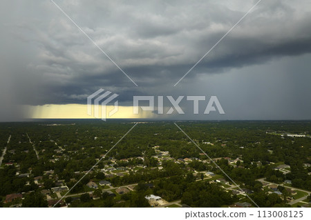 Landscape of dark ominous clouds forming on stormy sky during heavy thunderstorm over rural town area 113008125