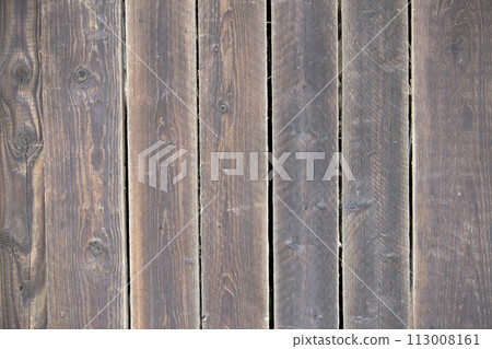 Close-up of natural old vintage weathered gray brown unpainted solid wooden fence or gate of planks and boards. Ecological texture vertical copy space sunny crackled background. Close-up of natural old vintage weathered gray brown unpainted solid wooden fence or gate of planks and boards. Ecological texture vertical copy space sunny crackled background. 113008161
