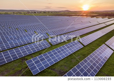 Blue solar photo voltaic panels system producing renewable clean energy on rural landscape and setting sun background. Blue solar photo voltaic panels system producing renewable clean energy on rural landscape and setting sun background. 113008193