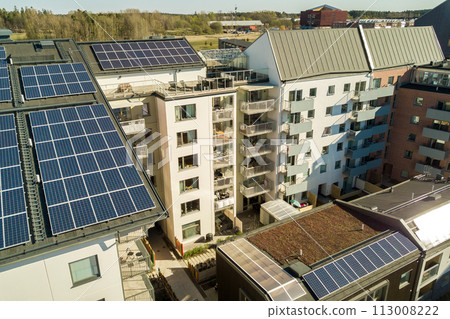 Aerial view of solar photovoltaic panels on a roof top of residential building block for producing clean electric energy. Autonomous housing concept. 113008222