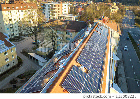 Aerial view of solar photo voltaic panels system on apartment building roof. Renewable ecological green energy production concept. 113008223
