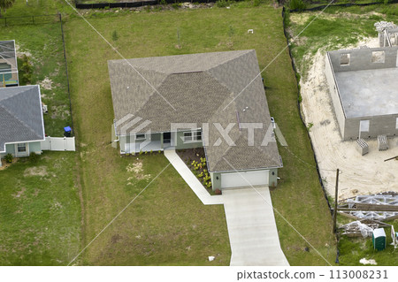 Aerial view of small town America suburban landscape with private homes between green palm trees in Florida quiet residential area Aerial view of small town America suburban landscape with private homes between green palm trees in Florida quiet residential area 113008231