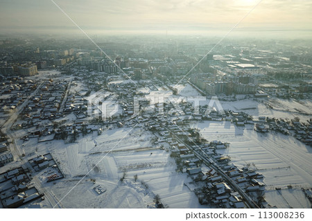 Aerial view of private homes with snow covered roofs in rural suburbs town area in cold winter 113008236
