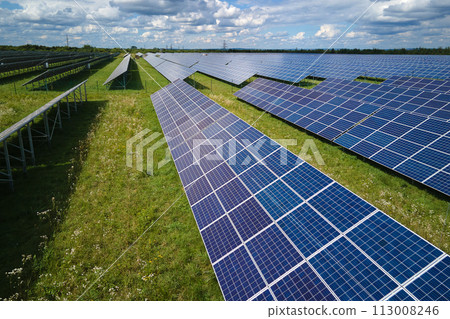 Aerial view of large sustainable electrical power plant with rows of solar photovoltaic panels for producing clean electric energy. Concept of renewable electricity with zero emission Aerial view of large sustainable electrical power plant with rows of solar photovoltaic panels for producing clean electric energy. Concept of renewable electricity with zero emission 113008246