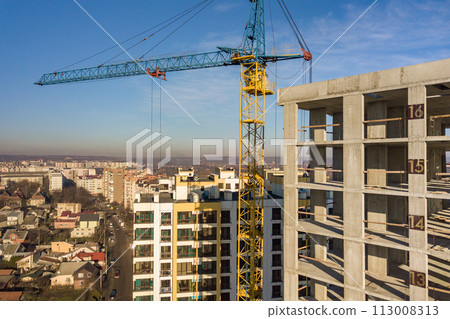 Aerial view of concrete frame of tall apartment building under construction in a city. 113008313