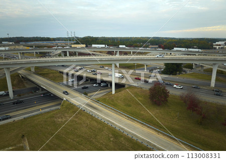 Aerial view of american freeway intersection with fast moving cars and trucks. USA transportation infrastructure concept Aerial view of american freeway intersection with fast moving cars and trucks. USA transportation infrastructure concept 113008331