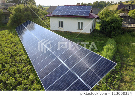 Aerial view of a house with blue solar panels for clean energy. 113008334