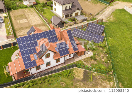 Aerial top view of new modern residential house cottage with blue shiny solar photo voltaic panels system on roof. Renewable ecological green energy production concept. 113008340