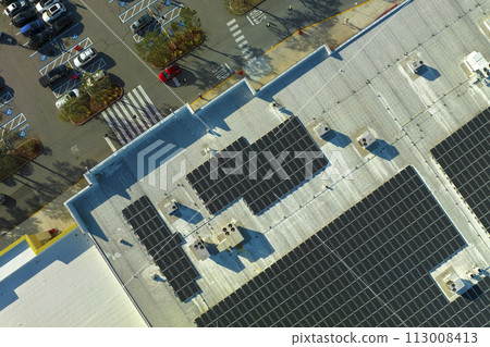 Electric photovoltaic solar panels installed on shopping mall building rooftop for production of green ecological electricity. Concept of producing sustainable energy Electric photovoltaic solar panels installed on shopping mall building rooftop for production of green ecological electricity. Concept of producing sustainable energy 113008413