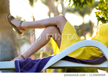 Young woman relaxing outdoors on sunny summer day. Happy lady lying down on comfortable beach chair daydreaming thinking. Calm beautiful smiling girl enjoying fresh air relaxing with closed eyes. Young woman relaxing outdoors on sunny summer day. Happy lady lying down on comfortable beach chair daydreaming thinking. Calm beautiful smiling girl enjoying fresh air relaxing with closed eyes. 113008494
