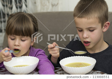 Two children boy and girl eating soup Two children boy and girl eating soup 113008551