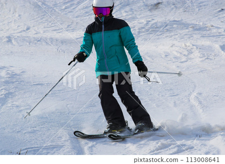 Skier skiing down a mountain alone 113008641