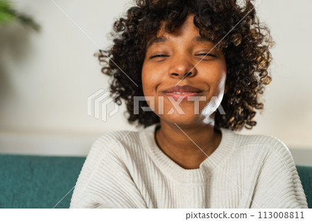 Beautiful African American girl with afro hairstyle smiling. Close up portrait of young happy black girl. Young African woman with curly hair laughing. Freedom happiness carefree happy people concept 113008811