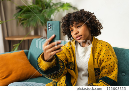 African American girl holding smartphone having video chat. Female blogger chatting with best friends in social network. Young woman having virtual meeting online chat video call at home 113008833