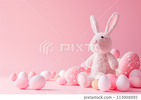 A rabbit is among a bunch of colorful Easter eggs. The rabbit looks adorable holds onto the eggs 113008895