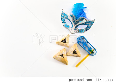 Jewish holiday Purim background with hamantaschen or hamans ears cookies, carnival mask and noisemaker 113009445